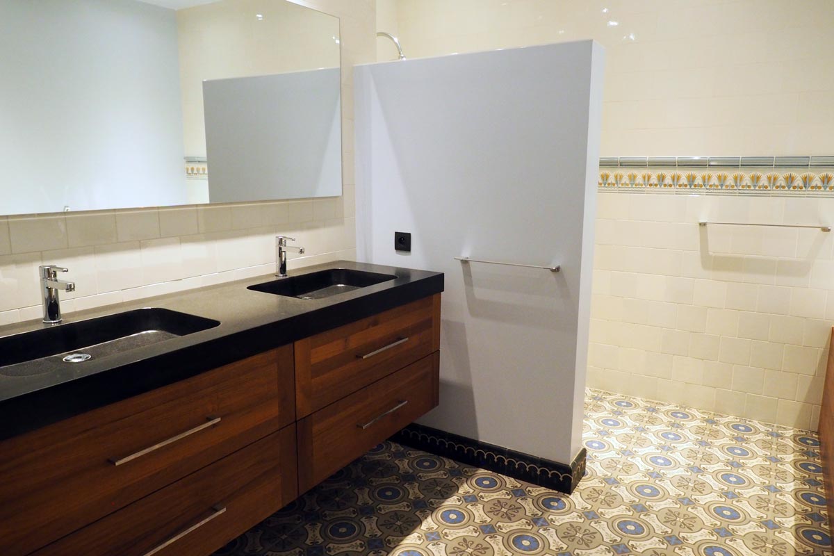 Le meuble en teak avec lavabo double en granit de la salle de bains à l'étage inférieur de la maison de vacances.